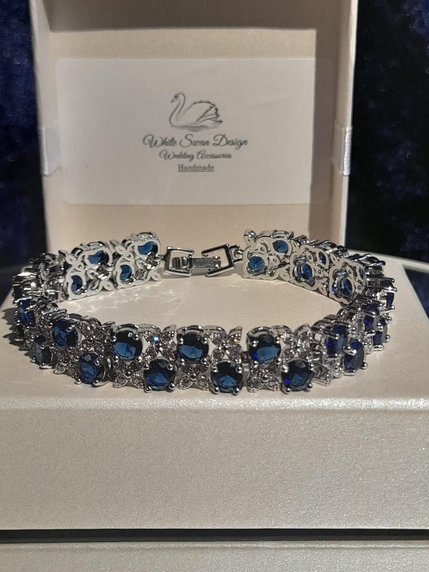 Silver bracelet with blue stones on a branded box