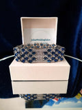 Blue and silver bracelet on a white box.