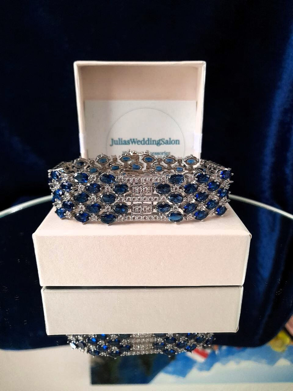 Blue and silver bracelet on a white box.