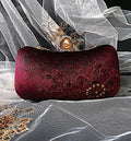 Wine Red clutch bag with floral embroidery on a white fabric background