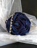 Navy blue rose-shaped handbag with decorative crystal silver chain on a white tulle background
