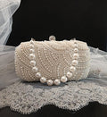 Pearl clutch bag in silver frame on a lace surface with a black background