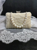 Pearl clutch bag in silver frame on a black background with lace fabric