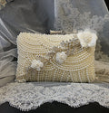Pearl clutch bag with floral embellishments on a lace background