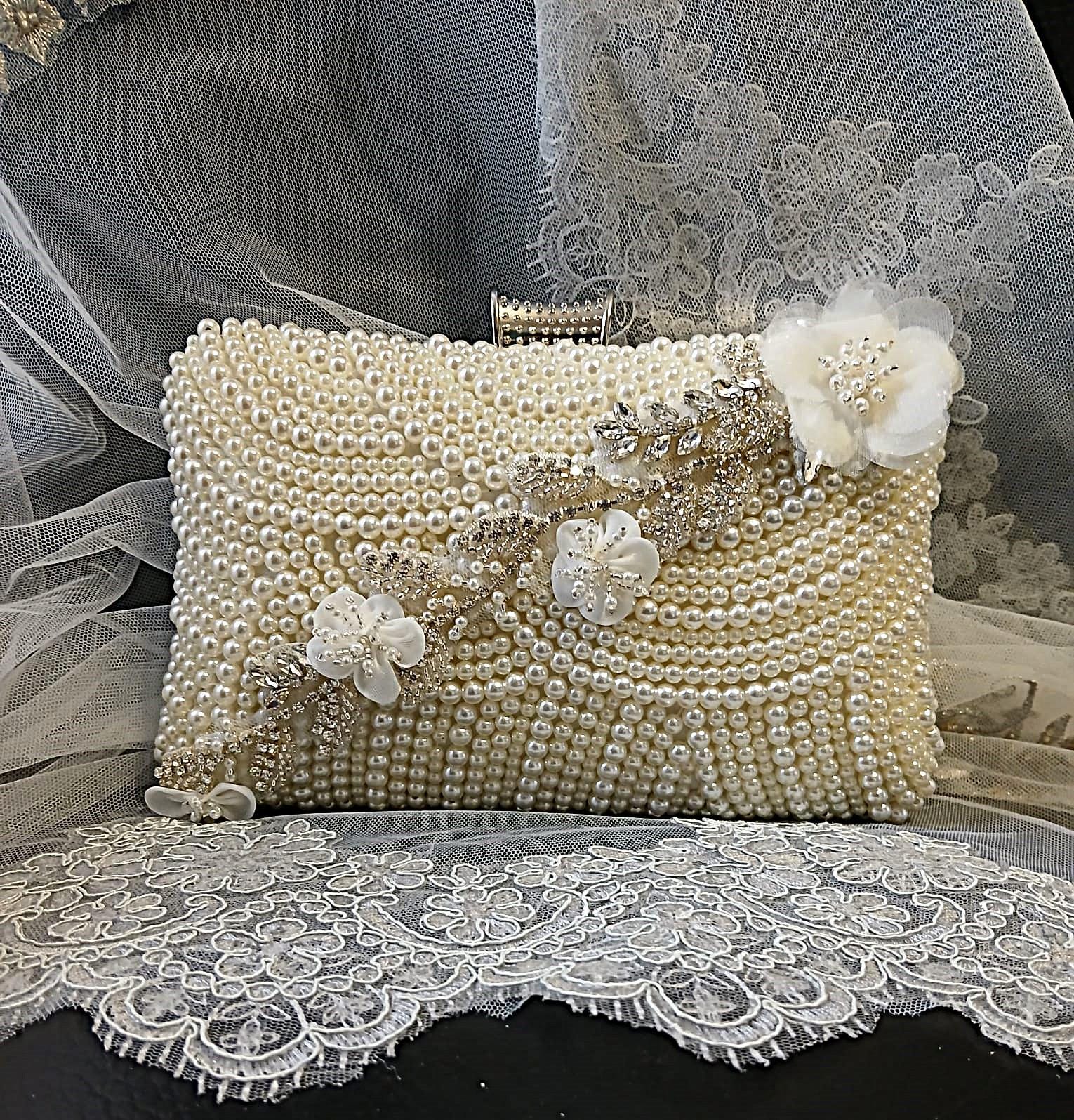 Pearl clutch bag with floral embellishments on a lace background