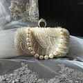 Pearl clutch bag in with gold harware on a decorative fabric background