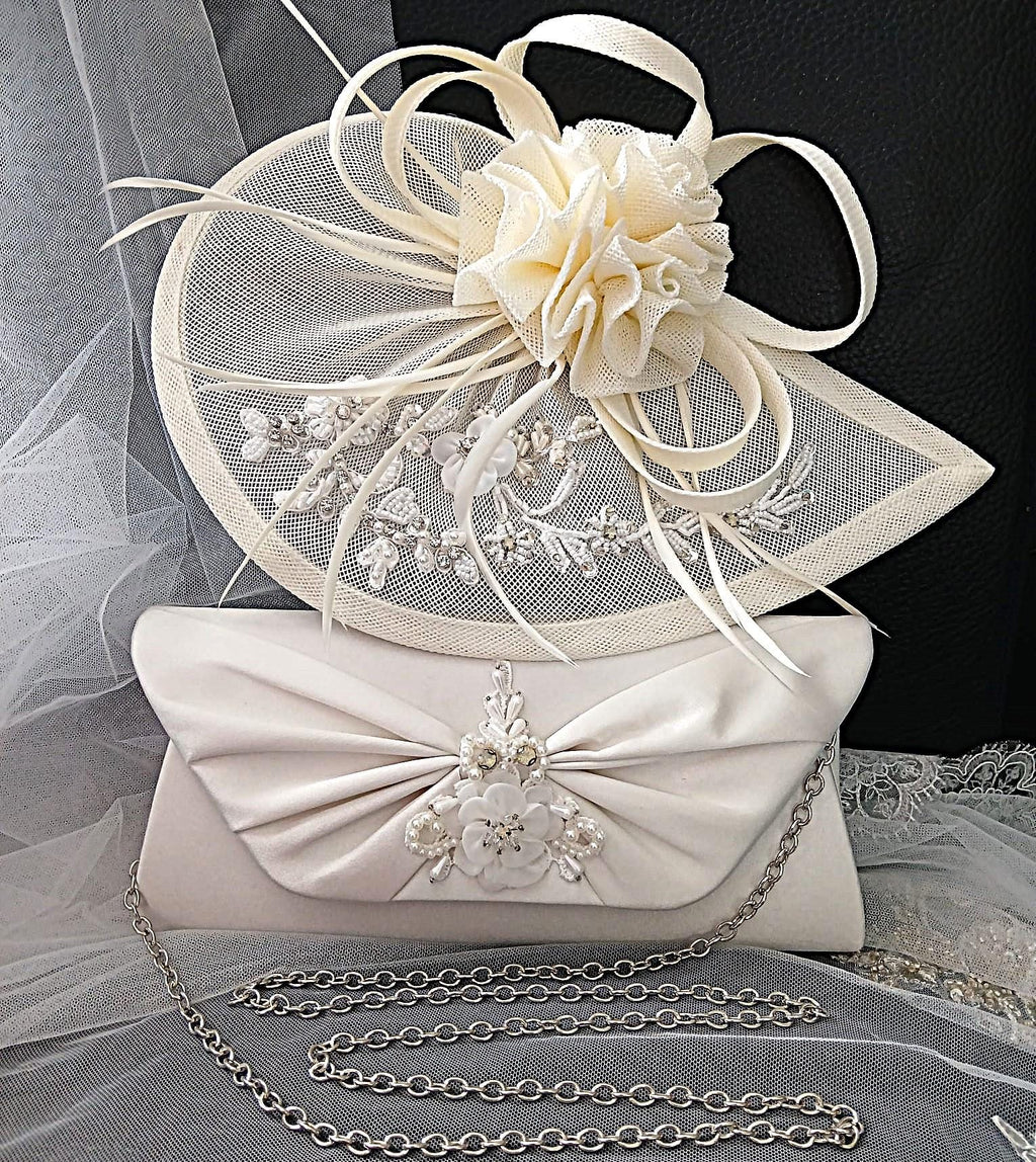 Ivory fascinator and clutch bag with decorative elements on a gray fabric background