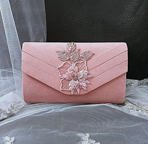 Pink clutch bag with floral embroidery on a black background