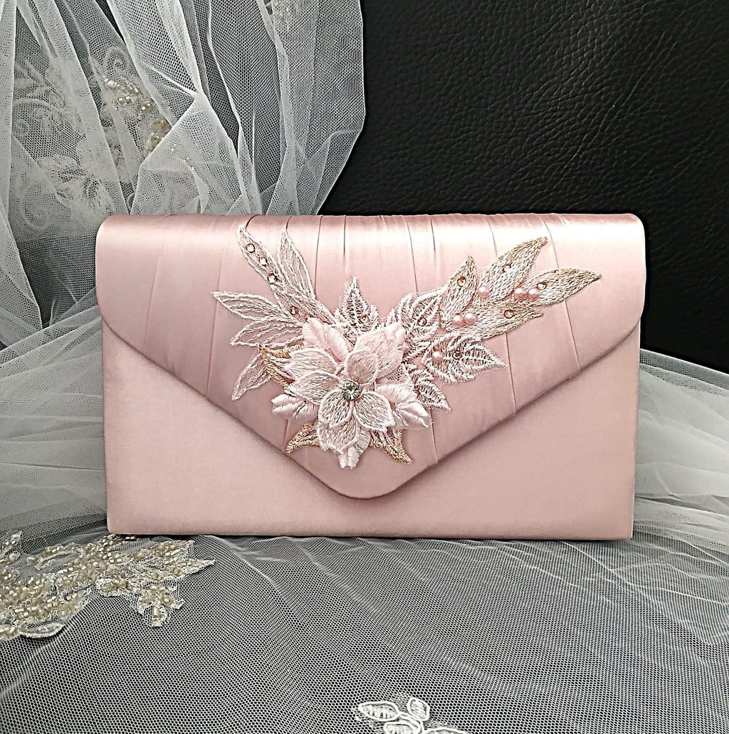 Pink clutch bag with floral embroidery on a decorative background