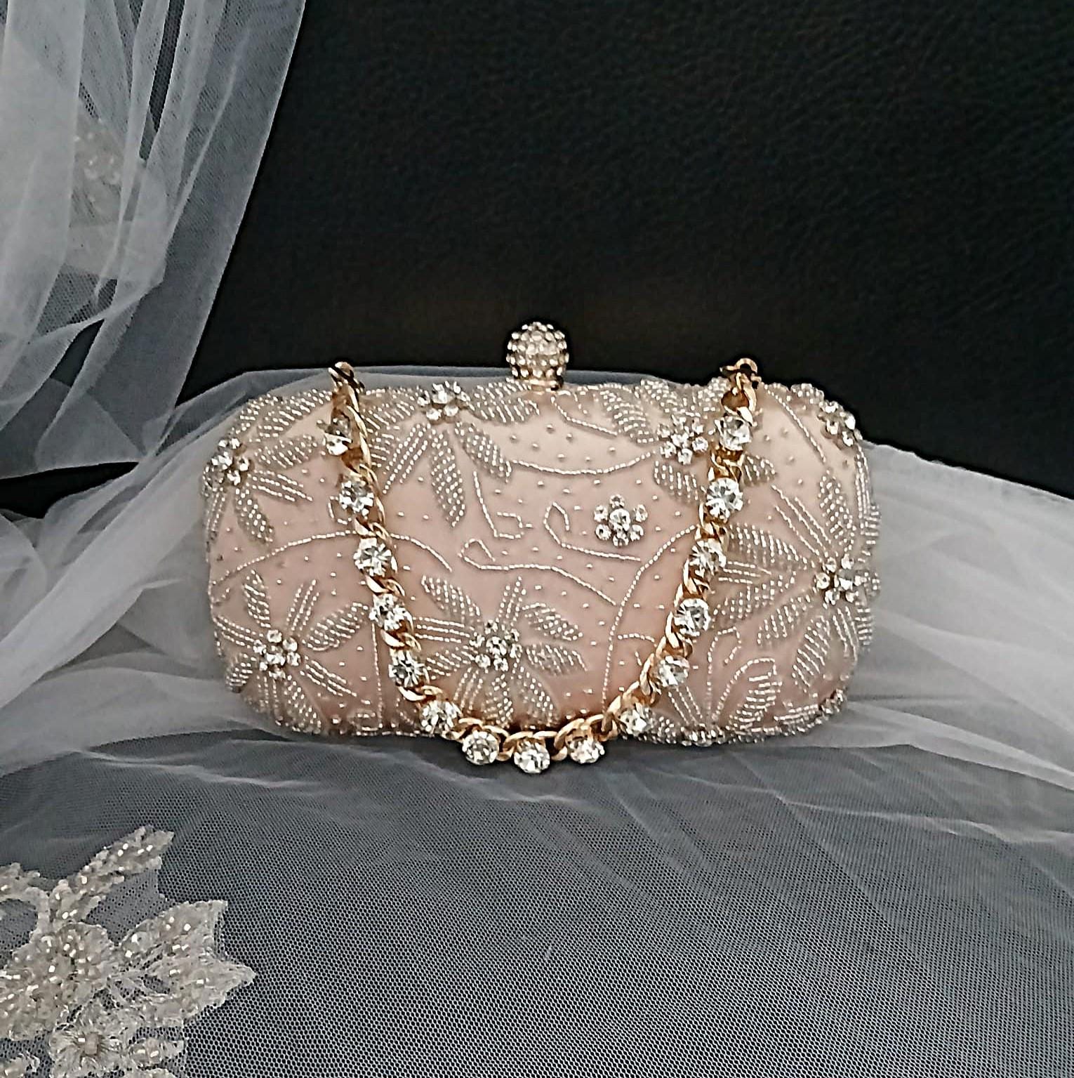 Champagne embroidered clutch bag with gold crystal chain on a black background