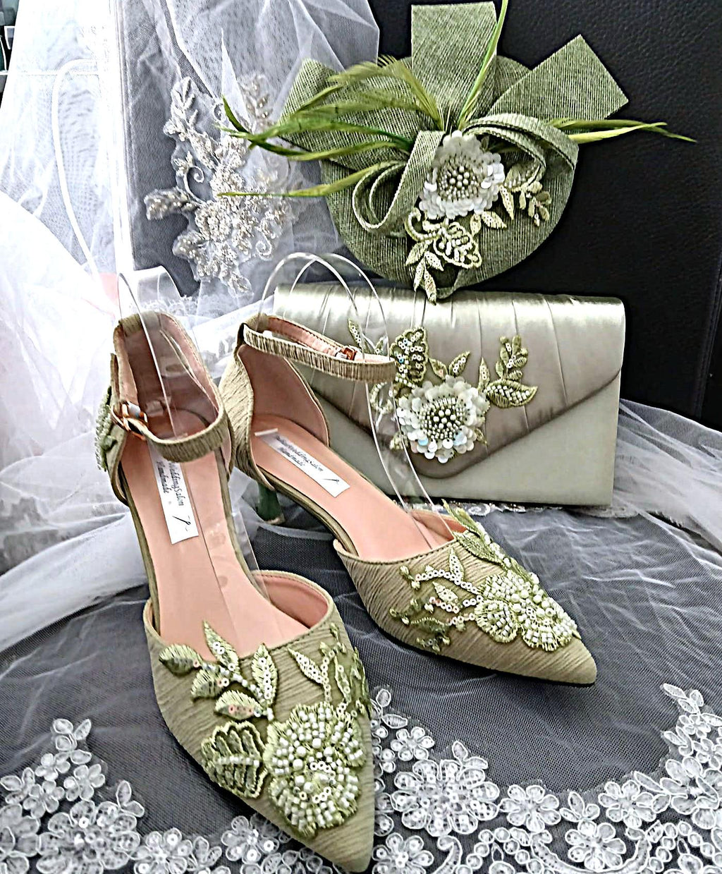 Green embroidered shoes with matching handbag and hat on a lace surface