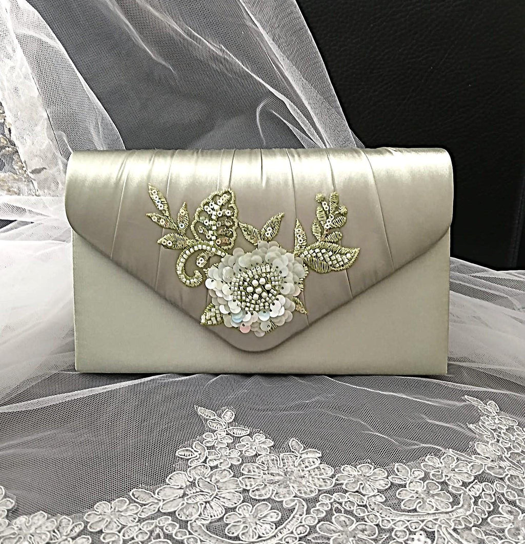 Sage Green clutch bag with floral embroidery on a lace fabric background