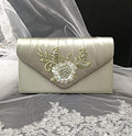 Sage Green clutch bag with floral embroidery on a lace fabric background
