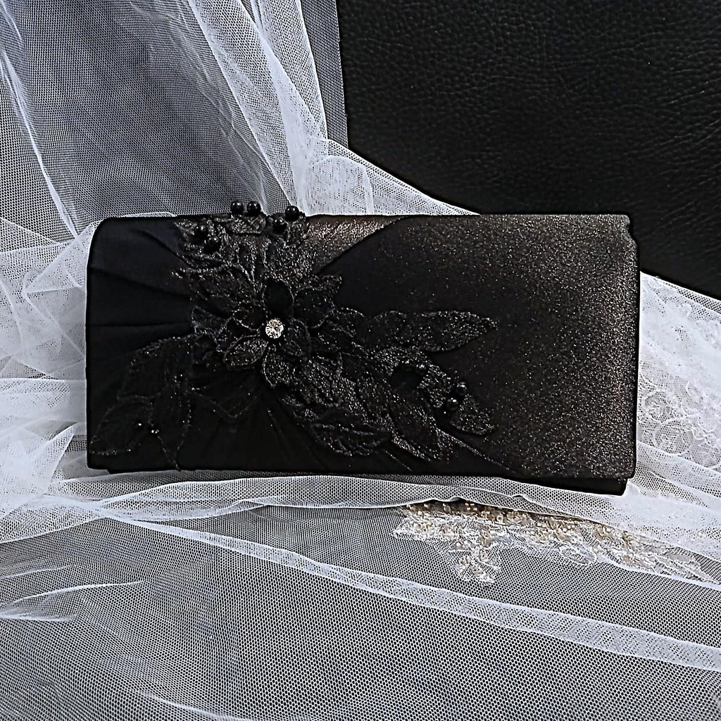 Black clutch bag with floral design on a white lace background