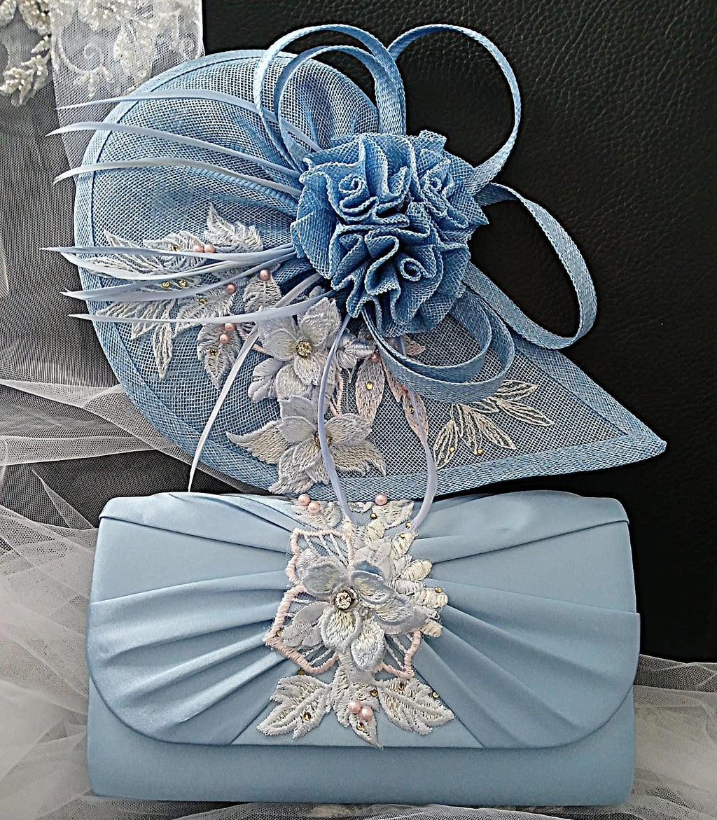 Light blue fascinator and matching clutch bag with floral embellishments on a textured surface.