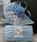 Light blue fascinator and matching clutch bag with floral embellishments on a textured surface.