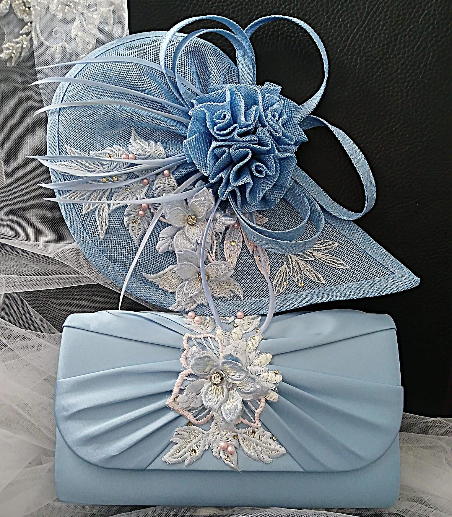 Light blue fascinator and matching clutch bag with floral embellishments on a textured surface.