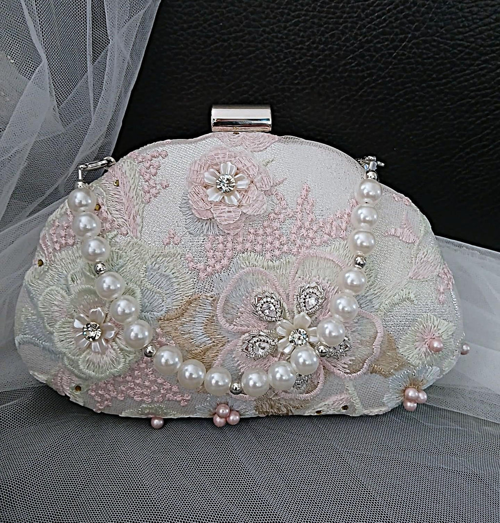 Decorated Silver handbag with floral patterns and pearls on a dark background