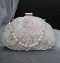 Decorated Silver handbag with floral patterns and pearls on a dark background