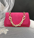 Fuchsia Pink handbag with gold chain handle on a black background