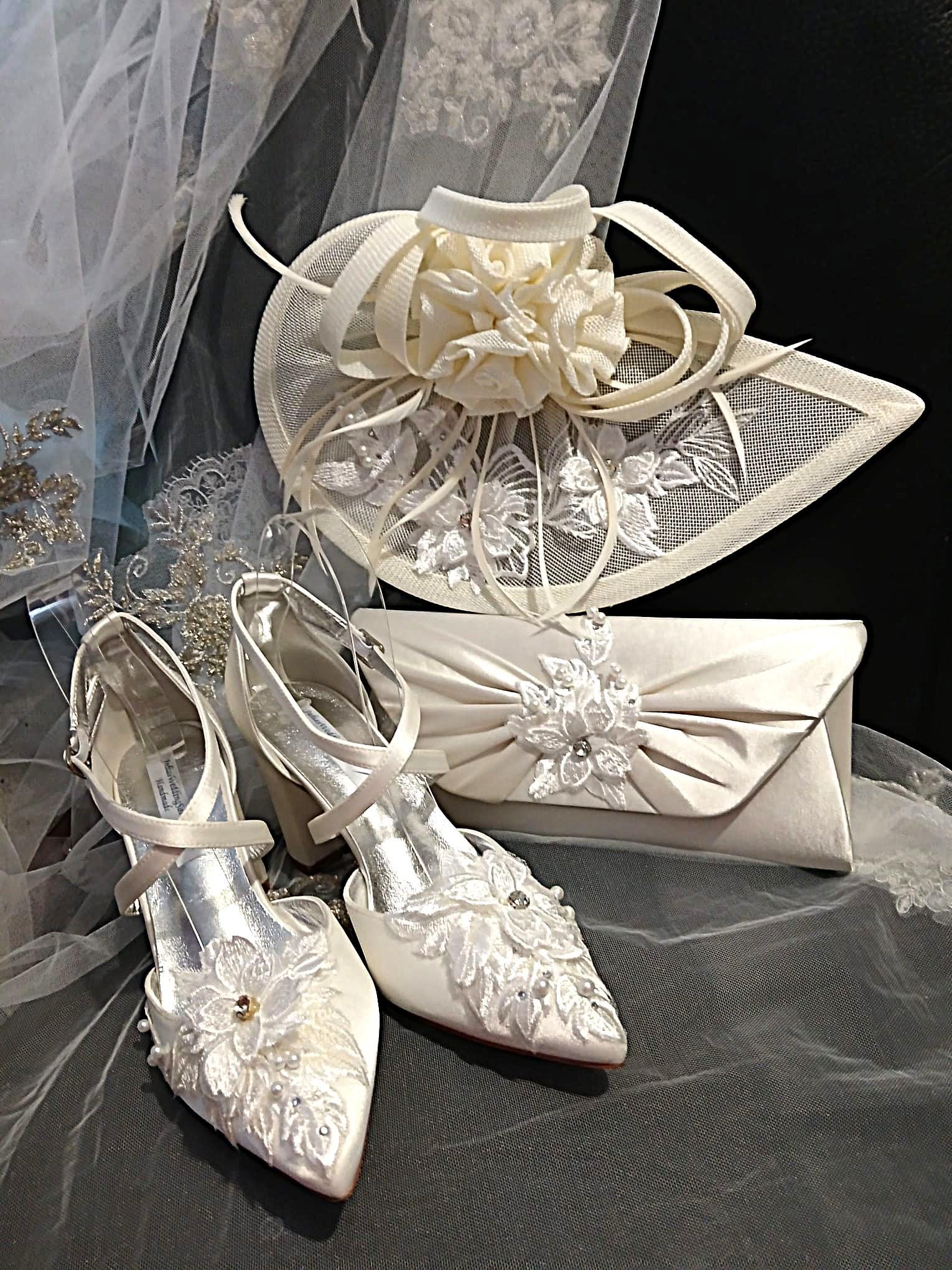 White wedding shoes, headpiece, and clutch on a dark background