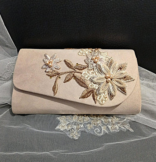 Beige clutch bag with floral embroidery on a black background