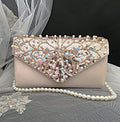 Elegant champagne clutch bag with beaded and sequined top section on a black background