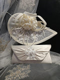 Ivory fascinator and matching clutch bag on a textured fabric background
