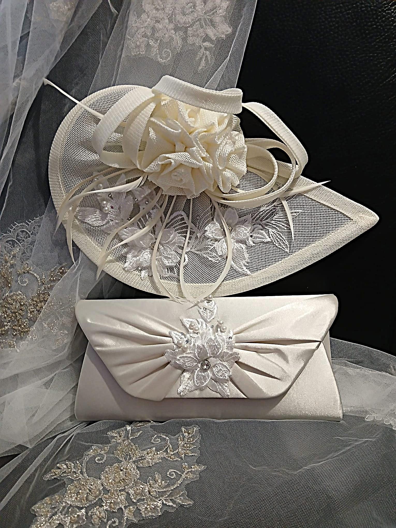 Ivory fascinator and matching clutch bag on a textured fabric background