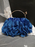Blue floral handbag with a gold handle on a black background