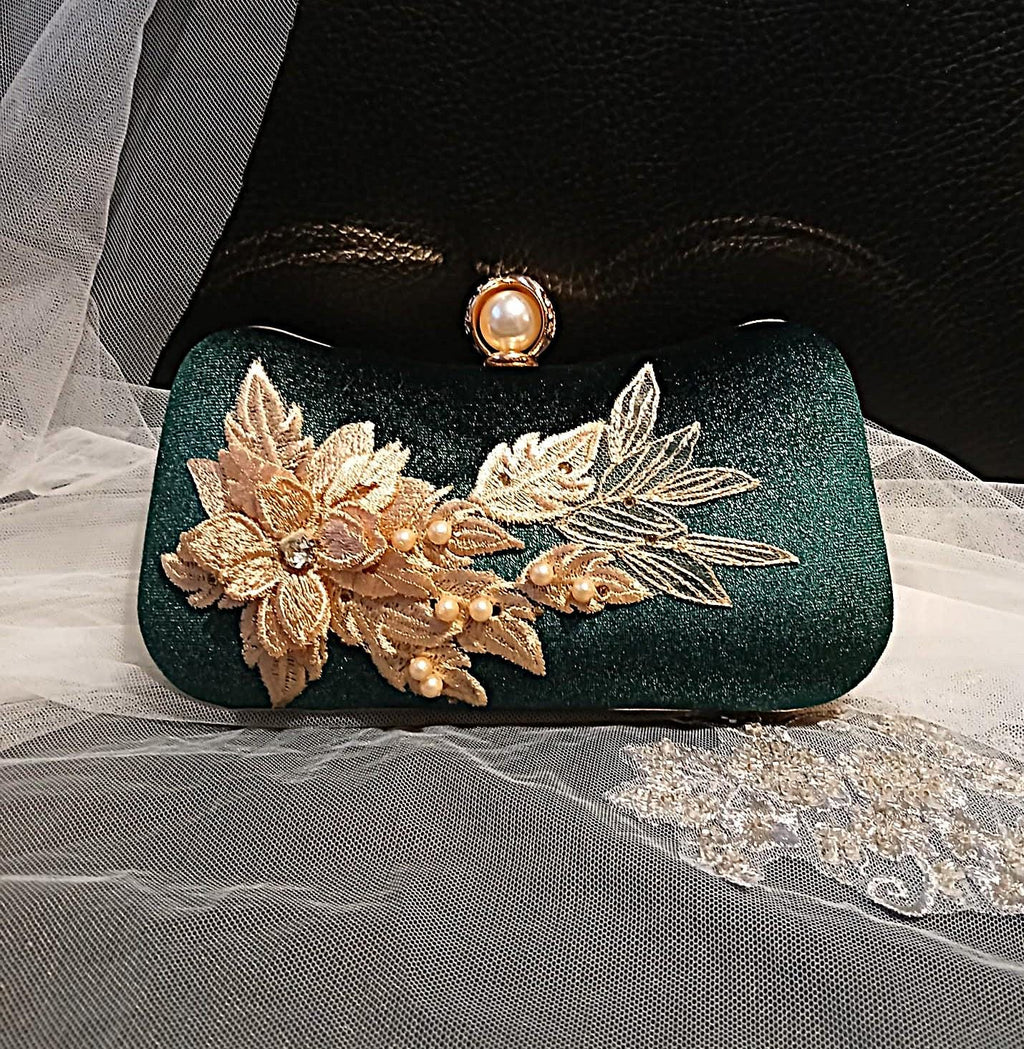 Green clutch with gold floral embellishments on a sheer fabric background