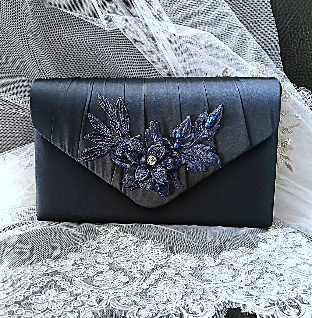Navy Blue clutch with floral embellishments on a lace fabric background