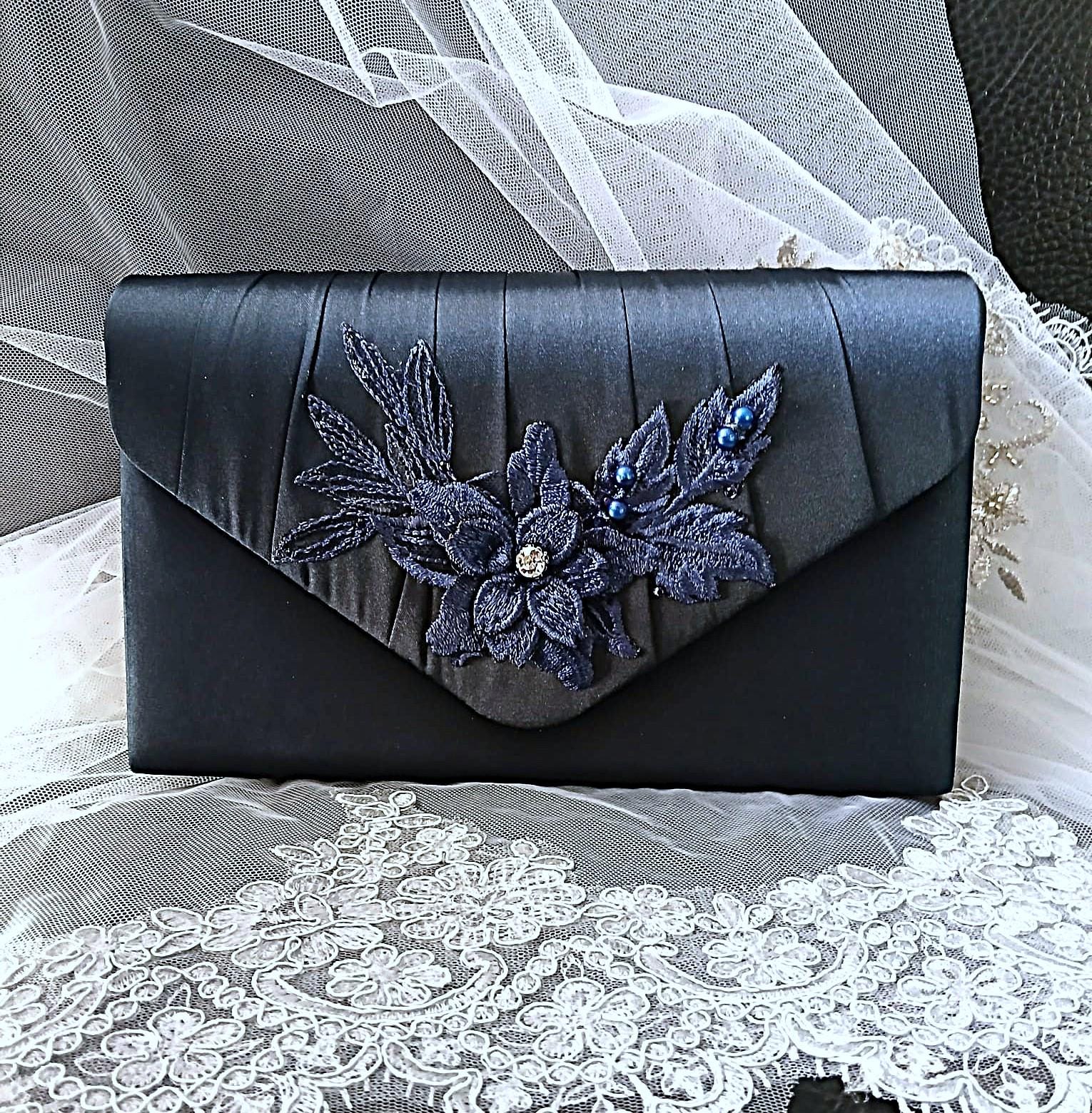 Navy Blue clutch with floral embellishments on a lace fabric background