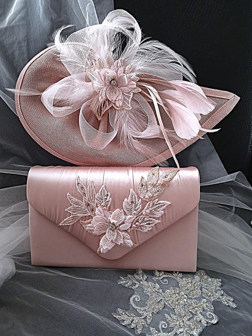 Pink fascinator and clutch bag with floral details on a gray fabric background
