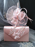 Pink handbag and hat with floral embellishments on a dark background